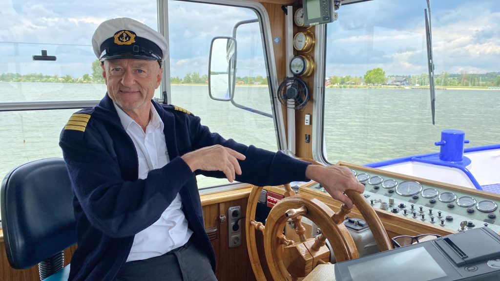 Herbert in Kapitänsuniform hinter dem Steuer der MS Altmühlsee